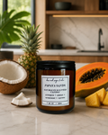 Papaya Sands candle with tropical fruits on a kitchen counter