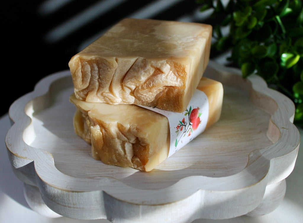 Two pieces of soap on a decorative white stand with a blurred background