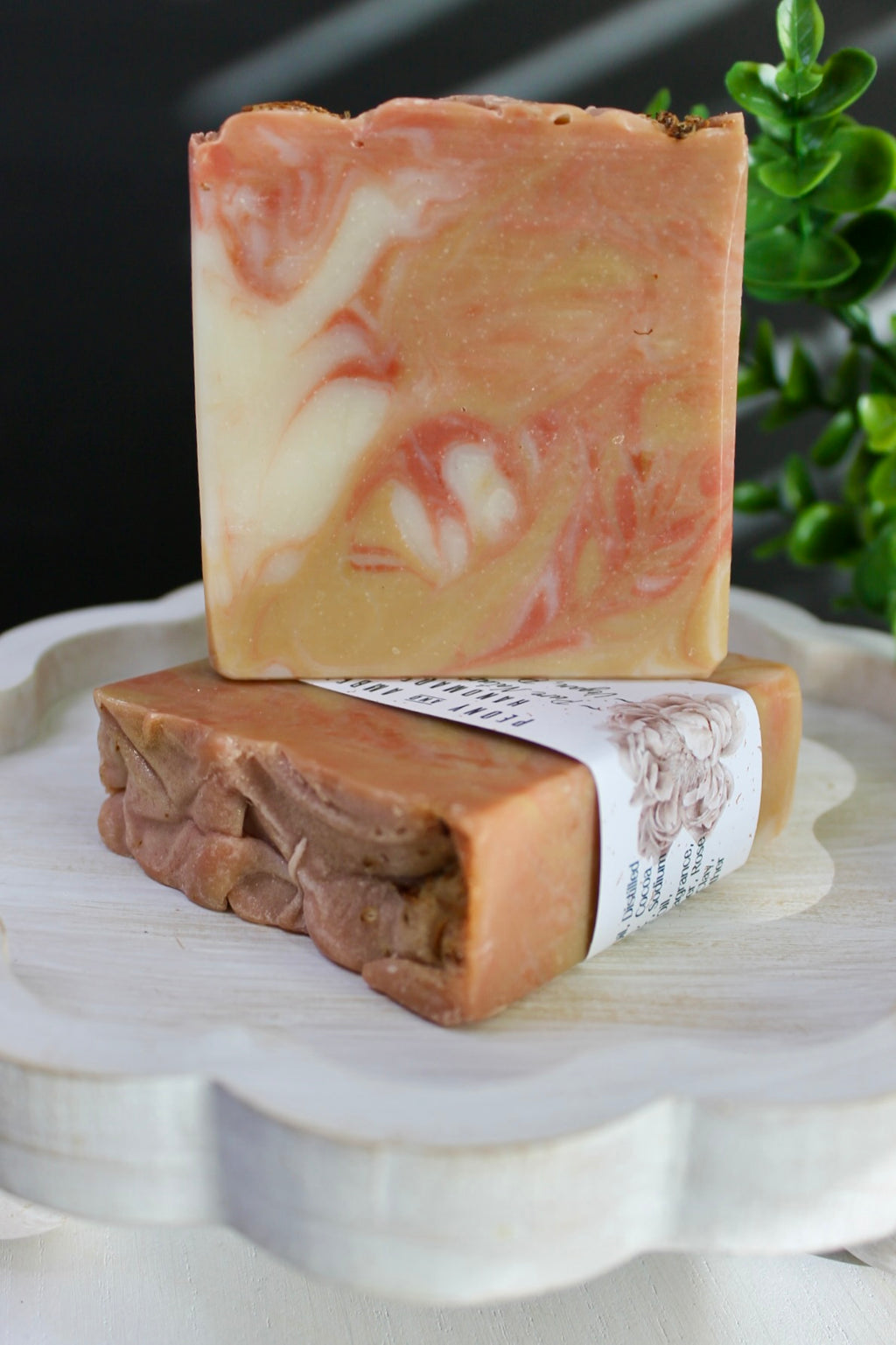 Two bars of soap with a marbled pattern on a white surface, one with a label.