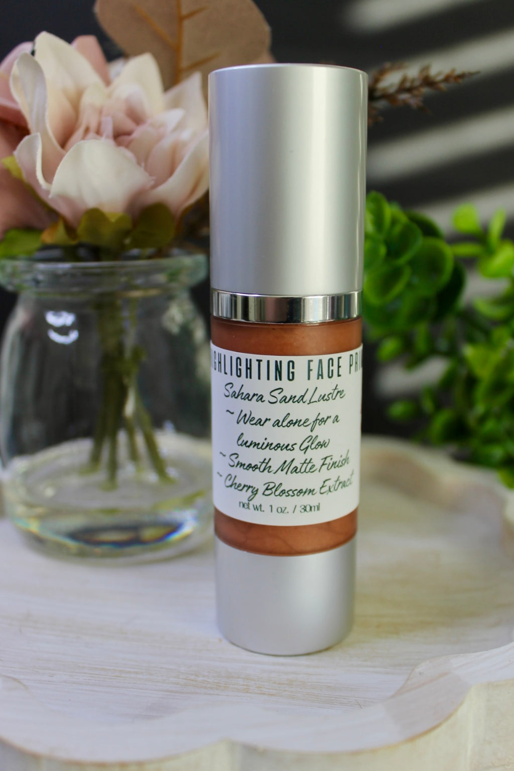 Skincare bottle with label on a wooden surface with flowers in the background