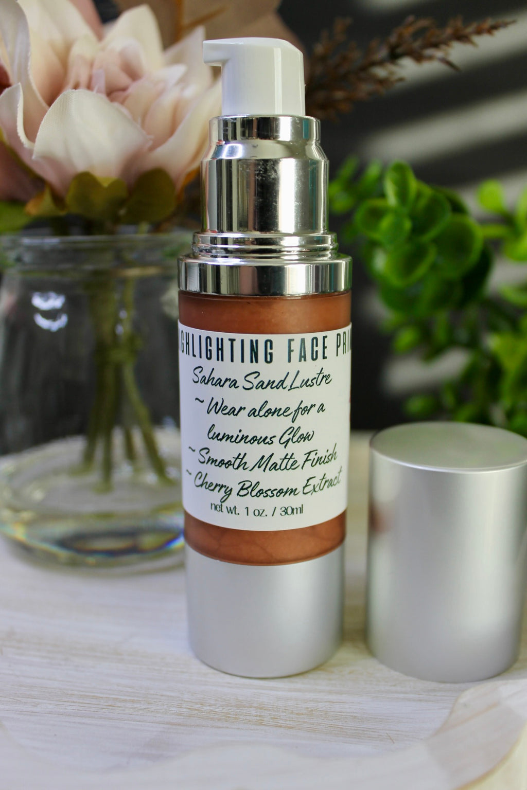 Skincare bottle with pump on a wooden surface with flowers in the background