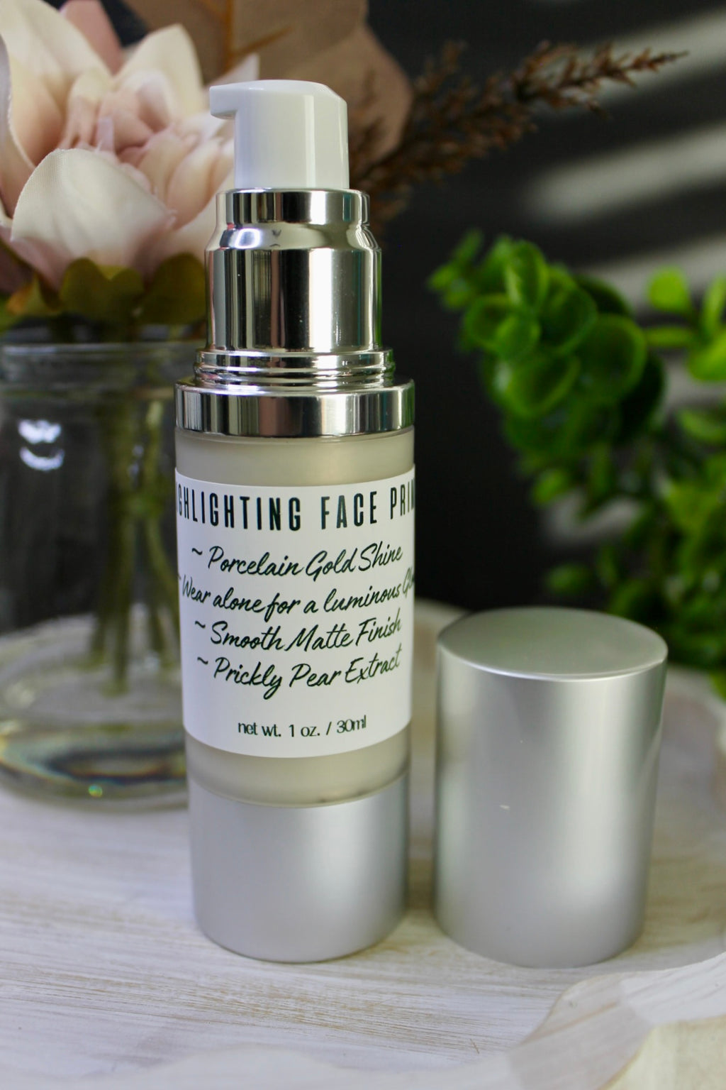 Skincare product with silver cap and white label on a marble surface