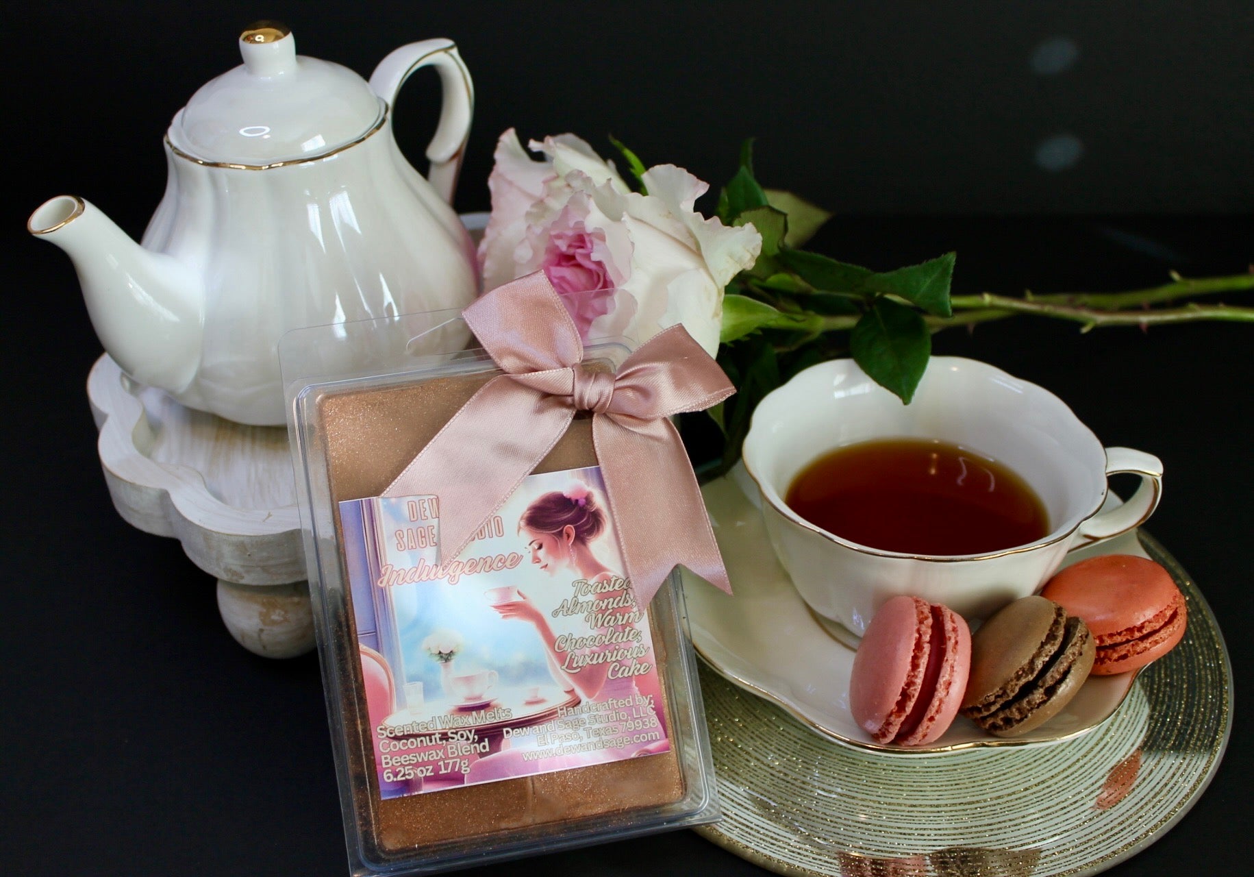 Tea set with teapot, cup, cookies, and wax melts on a dark background