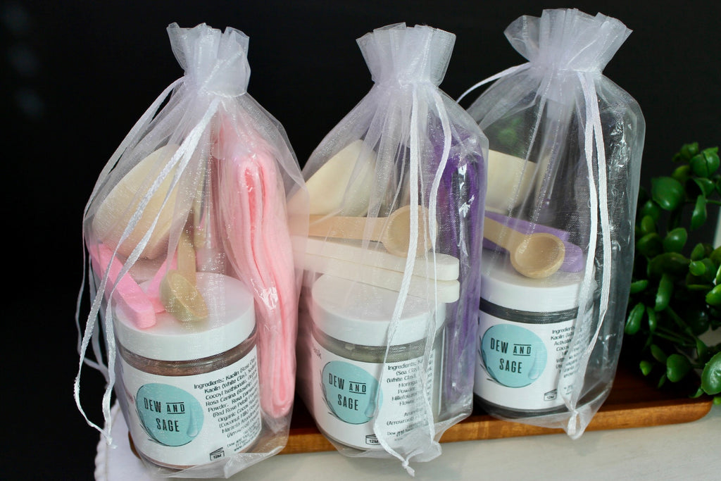 Three packages of Dew and Sage products on a wooden tray with a dark background