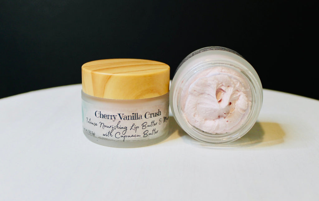 Two lip butter jars, one closed and one open, on a white surface with a black background.