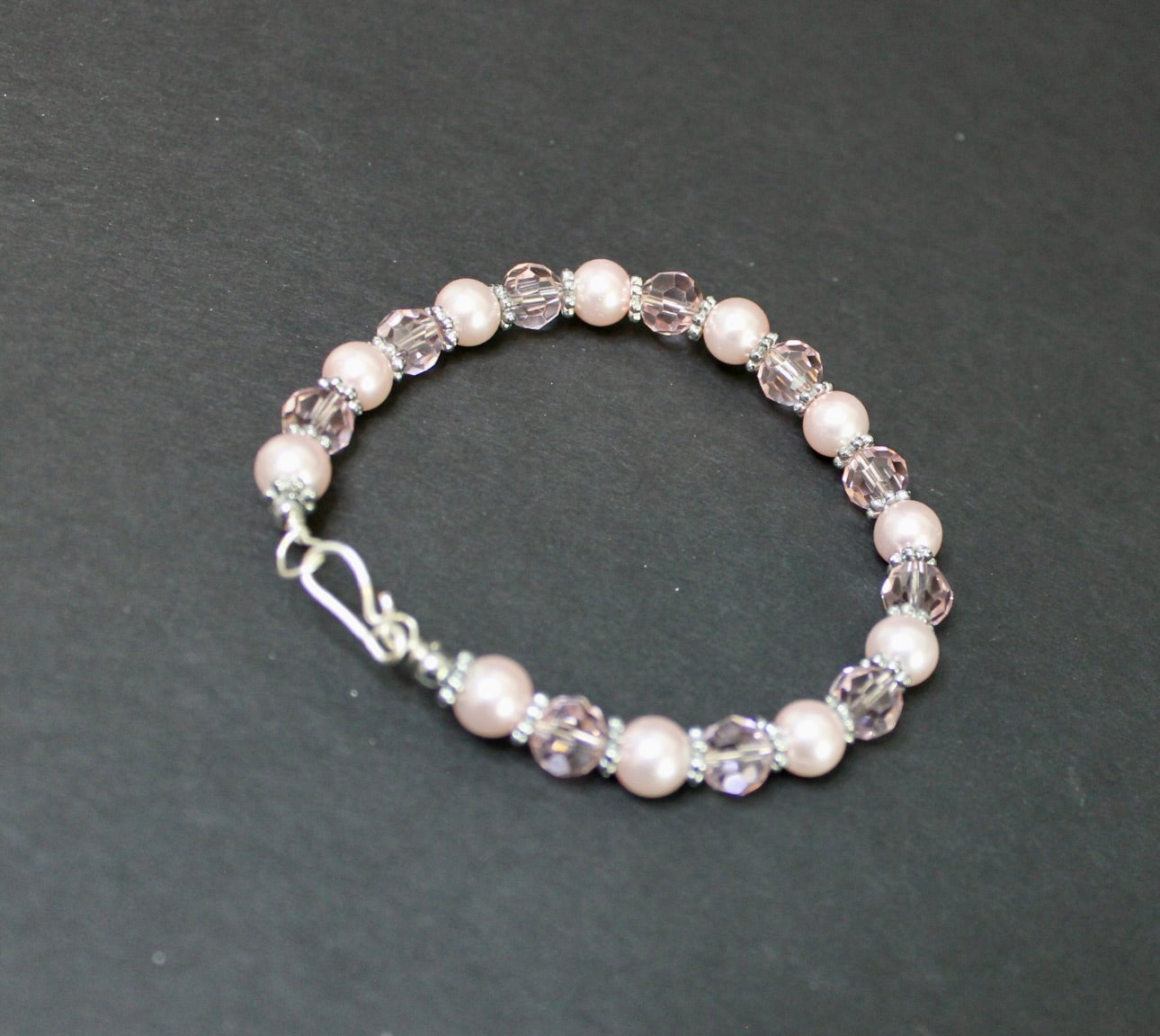 Beaded bracelet with pearls and crystals on a dark gray background