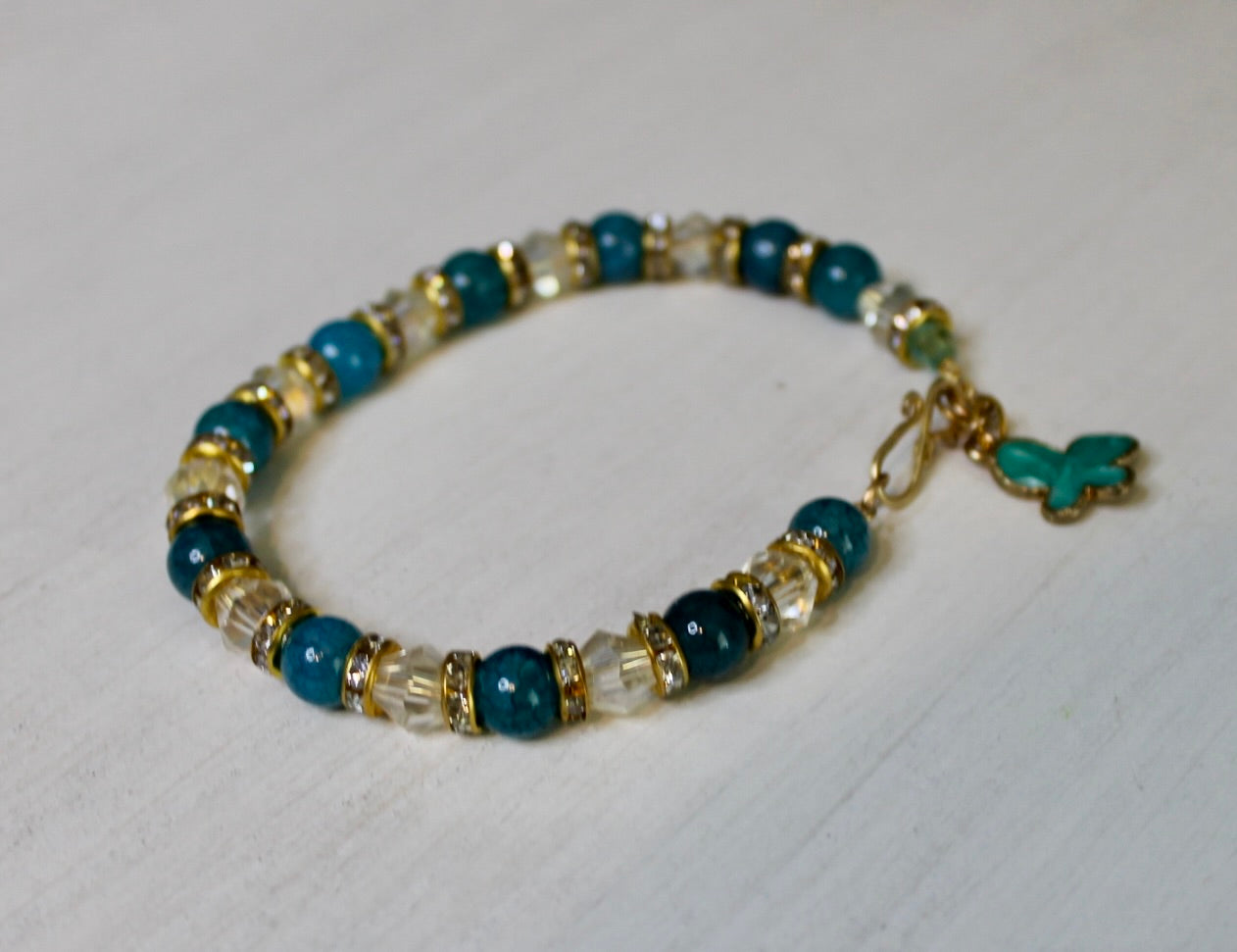 Beaded bracelet with blue, clear, and gold beads on a white background