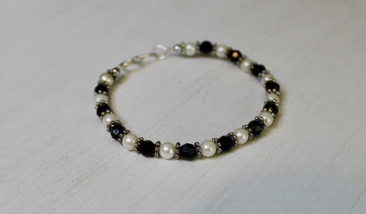 Bracelet with black and white beads on a light gray background